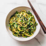Asian Zucchini Noodles: A Flavorful Low-Carb Twist You’ll Crave 4 Asian zucchini noodles in a white bowl with sesame and scallions