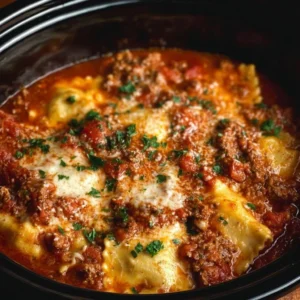 Delicious Crockpot Ravioli Lasagna topped with cheese and fresh herbs.